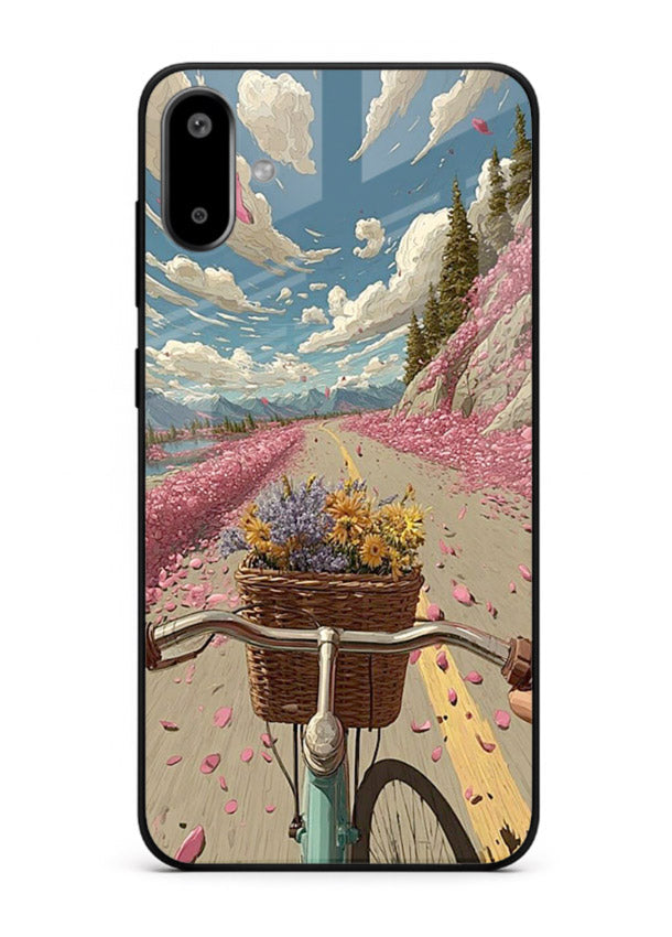 Bicycle with blossom-filled basket artwork on Samsung F06 5G glass back cover with soft scenic floral detailing.