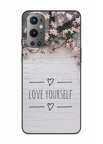 Floral self-love message printed on OnePlus 9 glass back cover with gentle pastel tones.