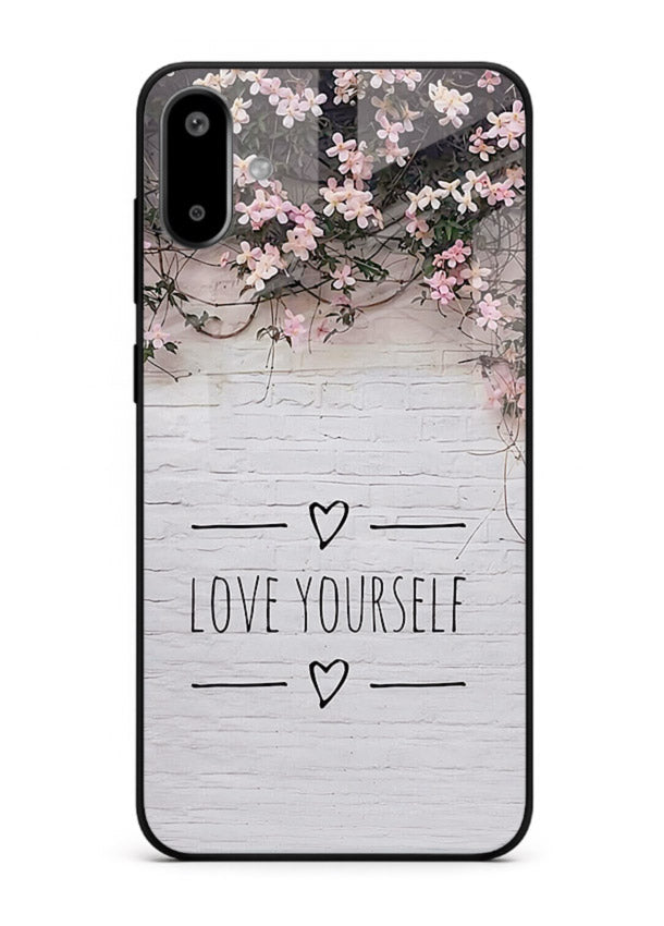 Floral self-love message printed on Samsung F06 5G glass back cover with gentle pastel tones.